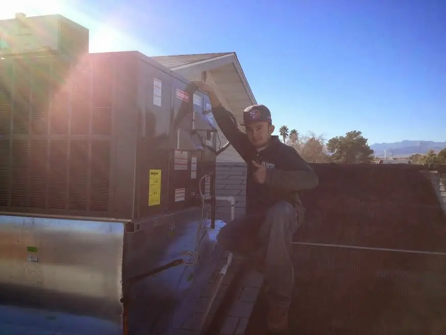 HVAC technician performing HVAC Inspection on a rooftop unit in New Boston